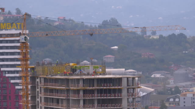 Workers-at-a-Construction-Site.-Crane-on-a-Construction-Site-Lifts-a-Load