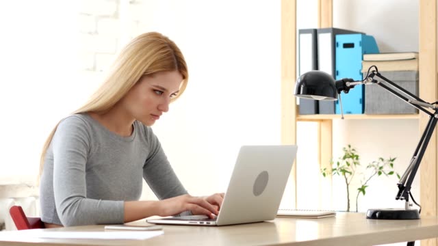 Frustrated-Young-Woman-Working-on-Laptop
