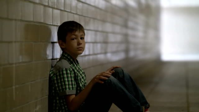 traurig,-einsam-misshandelte-Junge-sitzt-auf-dem-Boden-in-einem-Tunnel-in-Tiefe-Depression-in-die-Kamera-schaut,-ist-niemand-für-den-jungen-zu-Hause-warten
