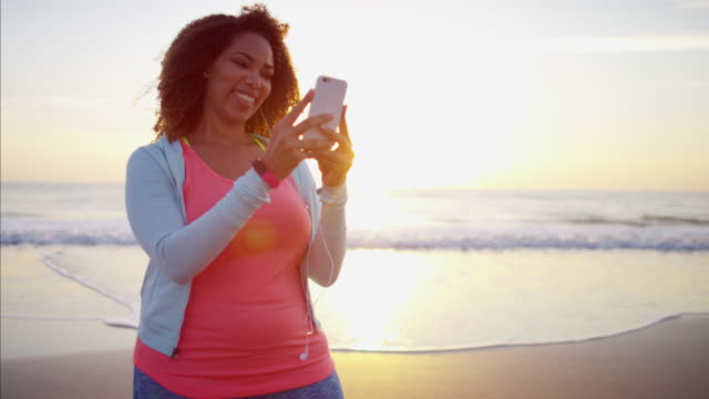 African-American-mujer-tomando-foto-selfie-en-playa