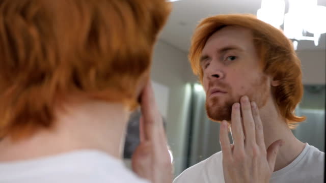Redhead-Beard-Man-Checking-at-His-Teeth-in-Mirror
