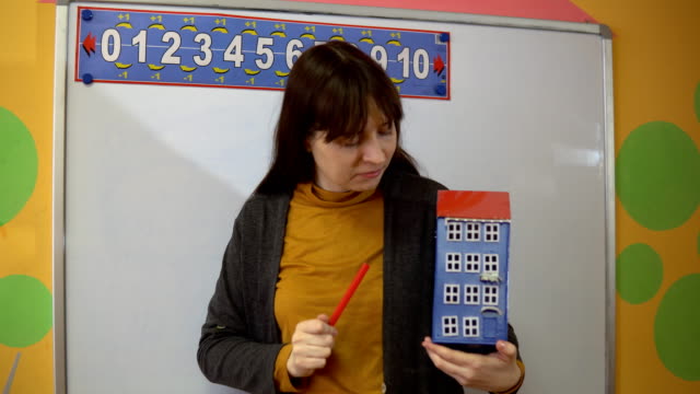 Female-teacher-stand-near-blackboard-in-elementary-school-teaching.