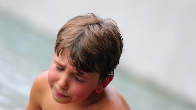 Child-sobbing-and-crying-by-the-poolside.-Real-life-authentic-sad-expressive-face-coming-from-kid-after-being-hurt