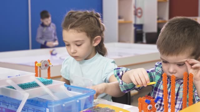 Children-creating-robots-at-school,-stem-education.-Early-development,-diy,-innovation,-modern-technology-concept.