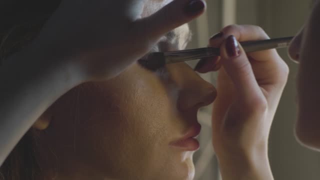 Make-up-Artist-mit-Kosmetik-Pinsel-zum-Auftragen-von-Lidschatten-am-Augenlid