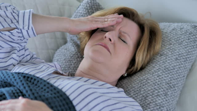 Senior-alte-mit-Kopfschmerzen-im-Bett-schlafen