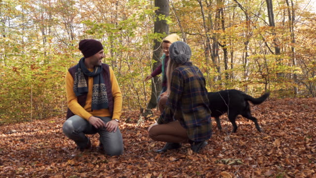 Familia-con-perro-divirtiéndose-en-el-bosque