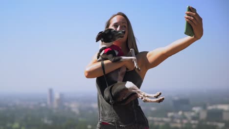 young-fit-woman-taking-scenic-selfies-on-her-cellphone-with-her-dog
