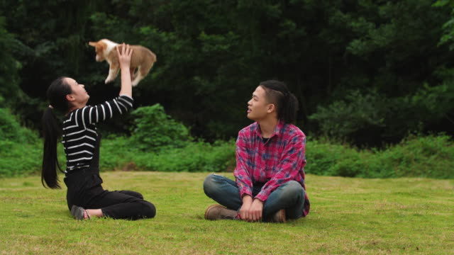 Glückliche-junge-Menschen-mit-Welpen-Hund-im-Freien,-Slow-motion