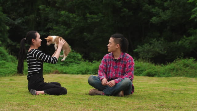 Glückliche-junge-Menschen-mit-Welpen-Hund-im-Freien,-Slow-motion