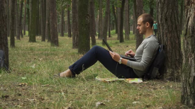 Young-man-is-working-on-laptop-in-the-forest