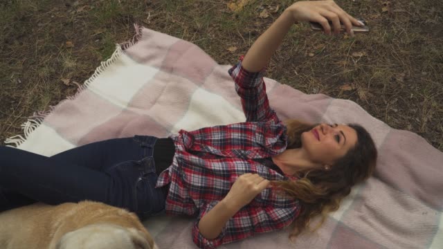 Junge-Frau-macht-Selfie-Handauflegen-Decke-im-Wald