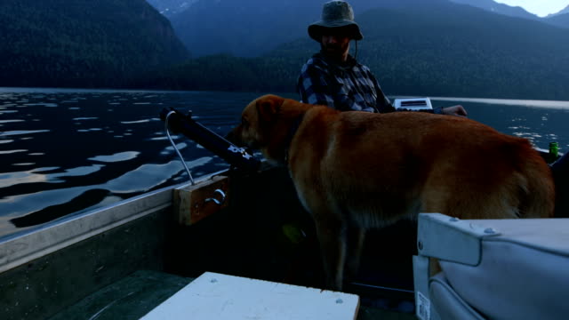 Fischer-angeln-mit-seinem-Hund-in-den-Fluss-4k