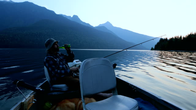 Fisherman-having-beer-while-fishing-in-the-river-4k