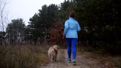 Female-trail-runner-with-pet-jogging-in-the-wood