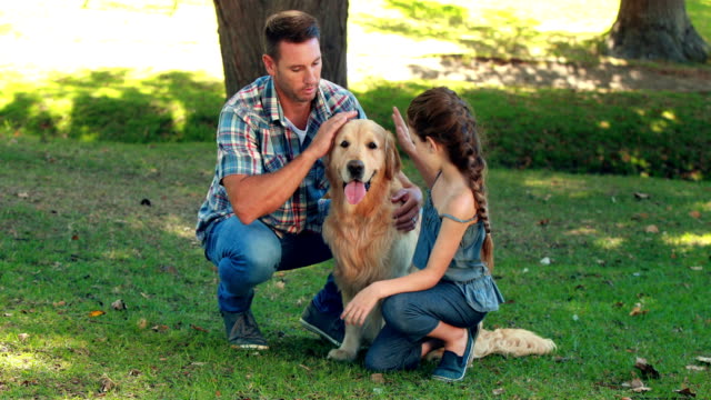 Vater-und-Tochter-mit-Ihrem-Haustier-Hund-im-park