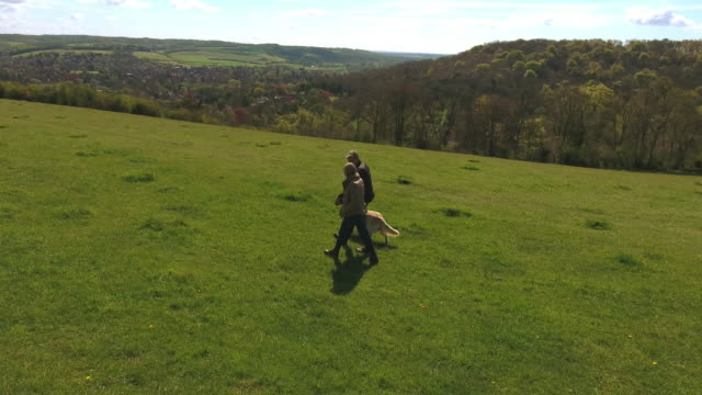 Aerial-Shot-Of-Mature-Couple-And-Dog-On-Walk-In-Countryside