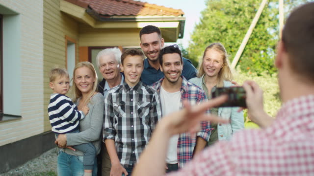 Hombre-tomando-fotos-al-aire-libre-de-su-gran-familia.