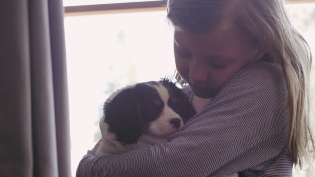 Cerrar-tiro-de-niña-abrazando-a-su-cachorro-adorable-y-envuelto-con-una-toalla