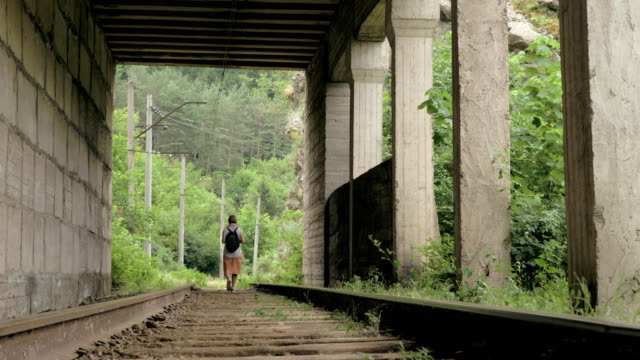Young-girl-walks-on-the-reailway-in-the-tunnel
