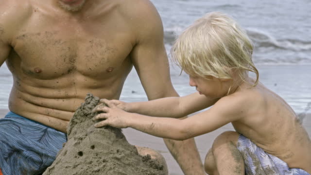 Dad-and-Little-Son-Building-Sandcastle-at-Ocean-Beach