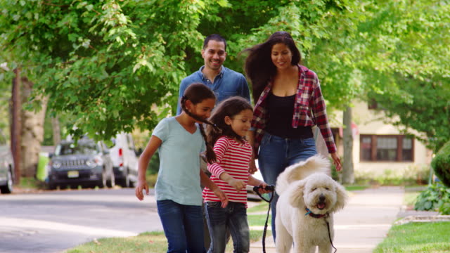 Familie-Hund-Suburban-Straße-entlang-spazieren-gehen
