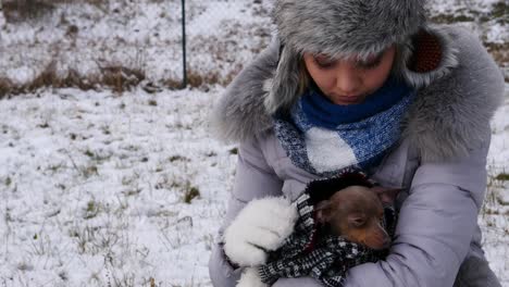 Mujer-preocupada-por-cuidar-del-perro-pequeño-durante-el-invierno