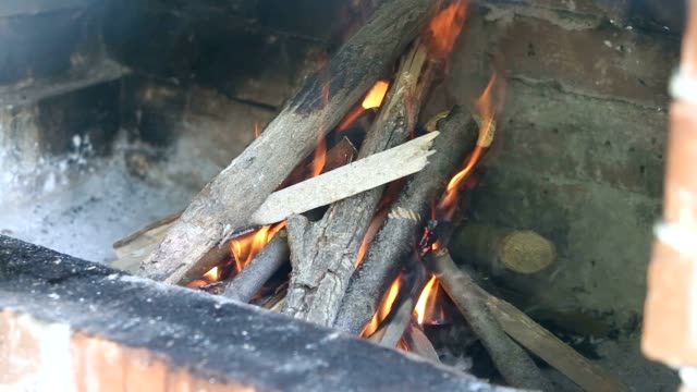 Holz-Feuer-in-einem-Kamin-aus-rotem-Backstein