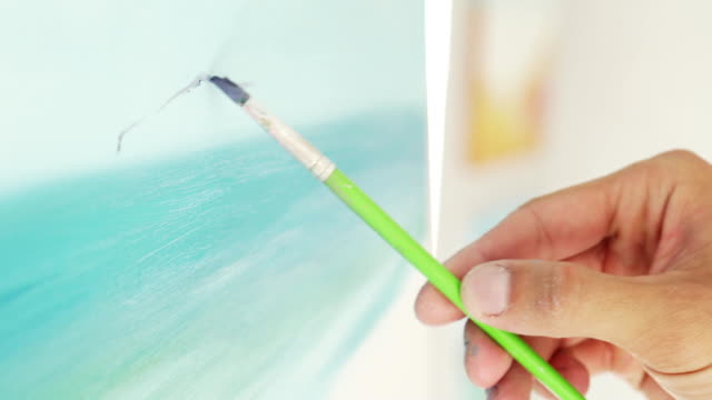 painter-paints-picture-on-canvas,-close-up