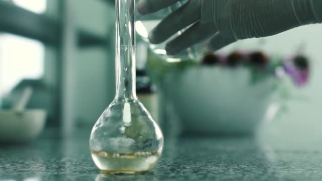 Laboratory-assistant-pours-the-water-into-the-flask