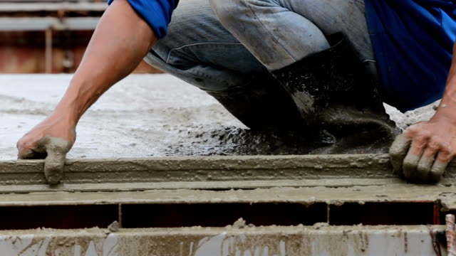 Industrie-Männer-Bauarbeiter-mit-Werkzeug-Beton-mischen-auf-Fußbodenkonstruktion