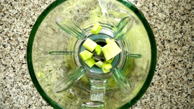 Stalk-of-an-apium-fall-in-a-blender-bowl.-Slow-motion.	Shooting-in-kitchen.-Top-view.