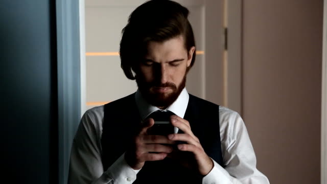 Bearded-handsome-young-man-using-his-smartphone.