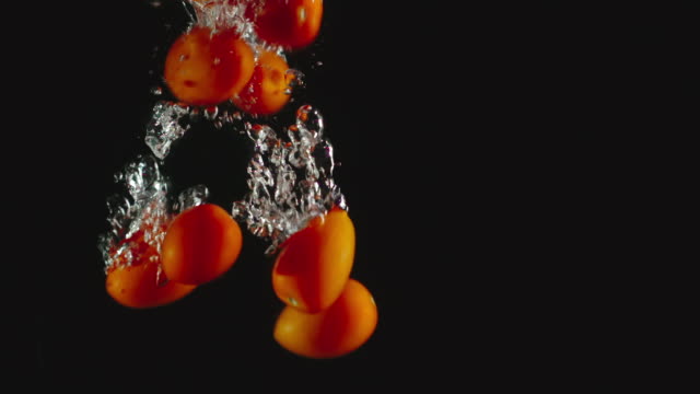 SLOW-MOTION:-Cherry-tomatoes-fall-under-water