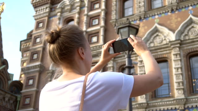 Woman-taking-pictures-of-Church-of-the-Savior-on-Blood-with-smartphone.