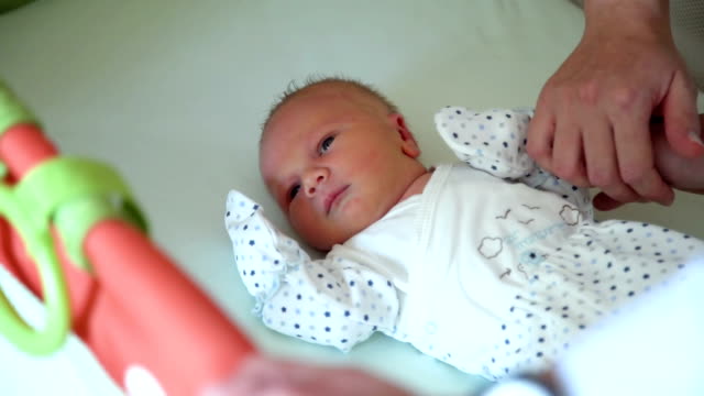 Parents-Petting-Newborn-Baby-in-Crib