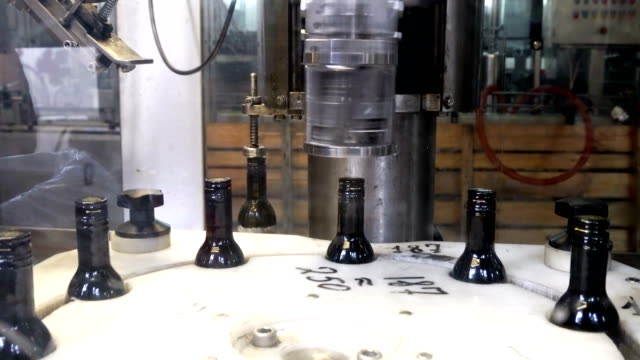 Spinning-caps-on-bottles-of-red-wine-using-professional-modern-equipment
