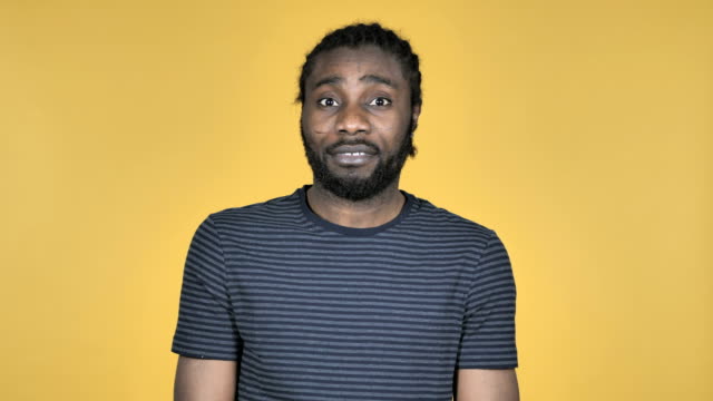 Casual-African-Man-Shaking-Head-to-Reject-Isolated-on-Yellow-Background