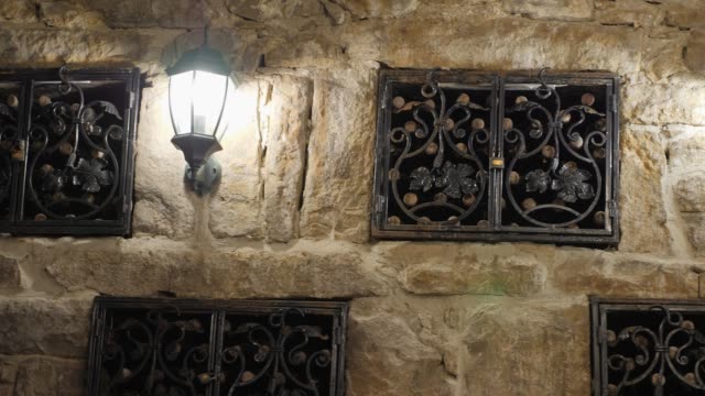 Storage-of-vintage-wine-in-the-wall-of-the-cellar-under-the-lock.-Excursion-around-the-winery-of-Crimea.-wine-cellar-is-lit-by-antique-lanterns.