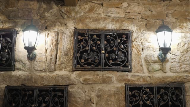 Storage-of-vintage-wine-in-the-wall-of-the-cellar-under-the-lock.-Excursion-around-the-winery-of-Crimea.-wine-cellar-is-lit-by-antique-lanterns.