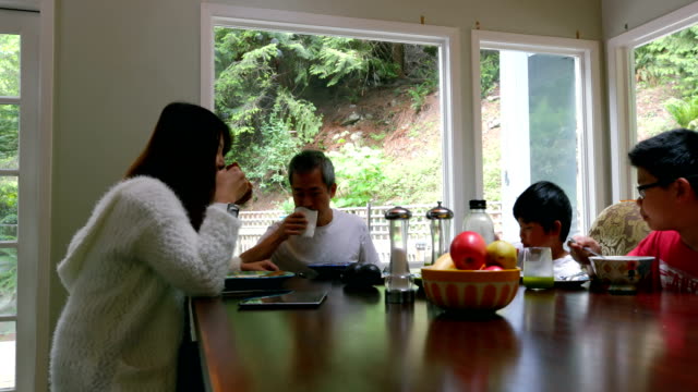 Family-members-having-breakfast-on-dining-table-4k