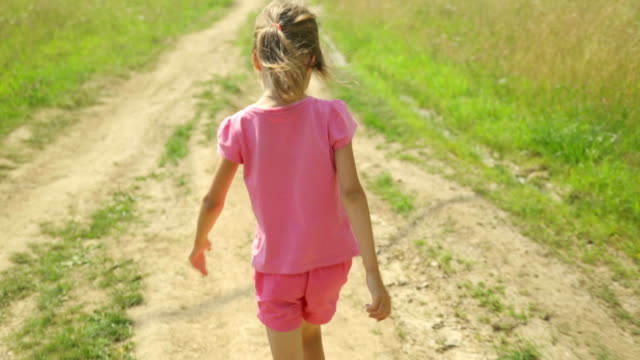 Little-girl-walking-along-a-rural-road