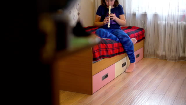Chica-practicando-la-flauta-en-su-cama-por-la-tarde