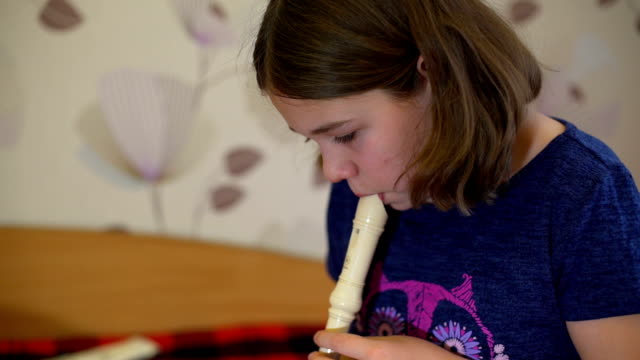 Girl-Practicing-Playing-Flute-at-Home
