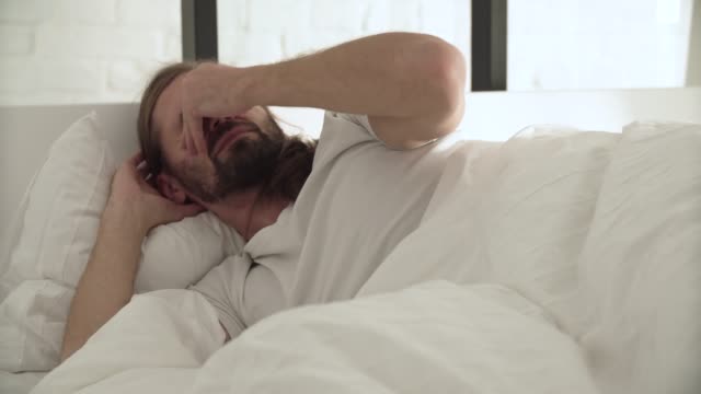 Mann-schläft,-Waking-Up-morgens-im-Bett-mit-weißer-Bettwäsche