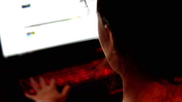 Chica-hacker-mujer-usando-la-pantalla-táctil-del-ordenador-portátil-en-la-habitación-oscura