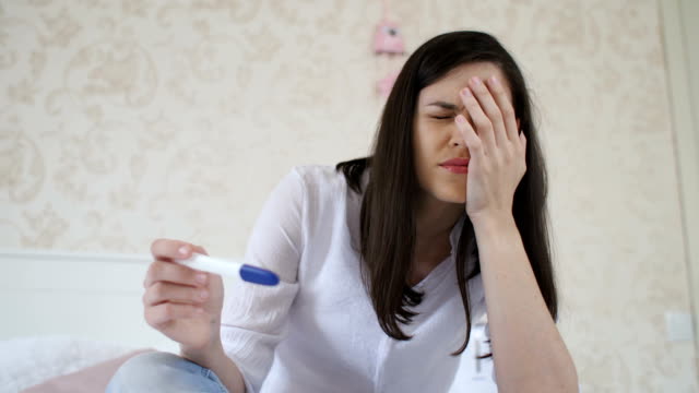 Sad-woman-with-pregnancy-test-at-home