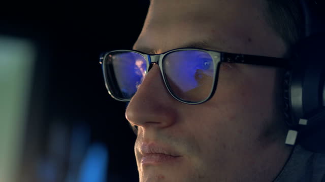 Close-up-of-a-computer-game-reflecting-in-gamer's-glasses