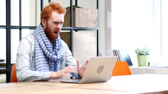 Beard-Man-Upset-by-Loss-while-Working-on-Laptop