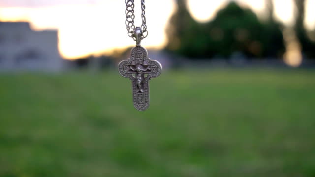 Christian-cross-on-a-chain-on-the-background-of-sunrise